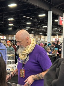 Man with snake wrapped around his neck